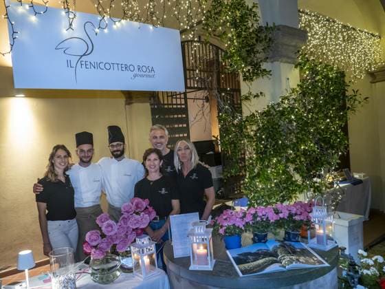 Sei persone dello staff, due con la toque da cuoco, si mettono in posa sotto l'insegna «Il Fenicottero Rosa»; davanti a loro il pozzo con le rose e le lanterne già accese. Manca poco al servizio.